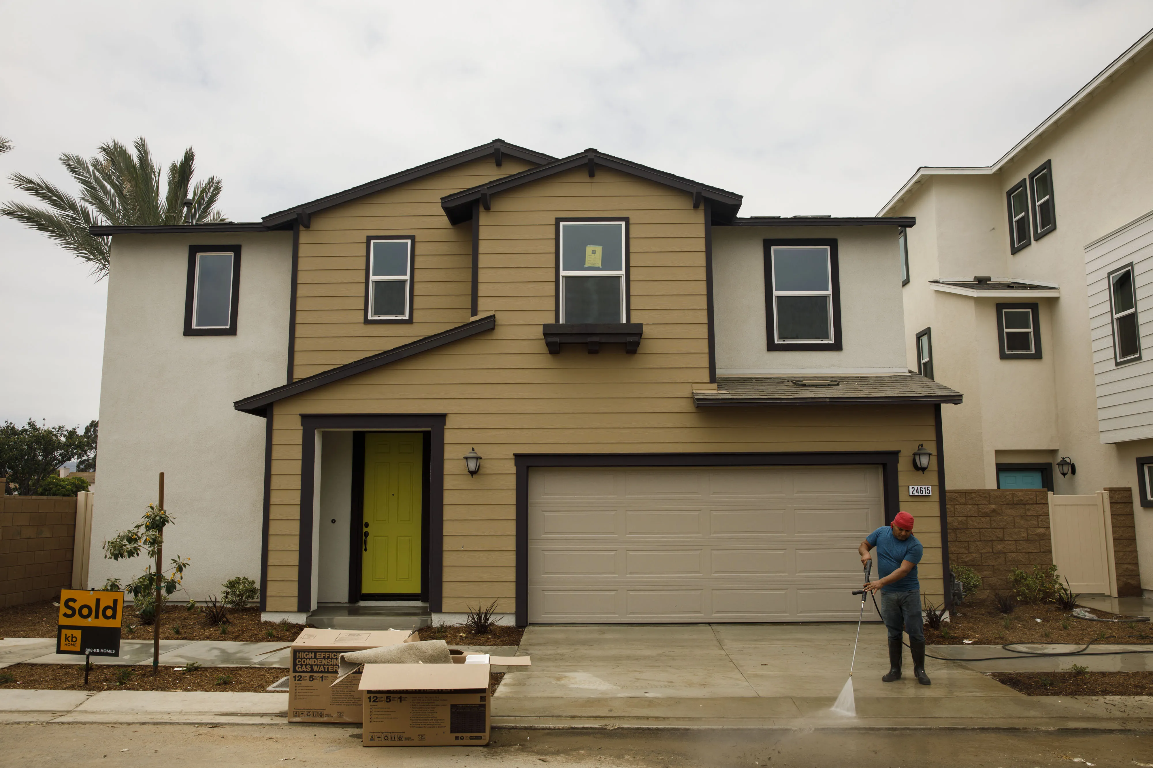 A contractor power washes the driveway of a new home at a development in Harbor City, California on June 22.&nbsp;