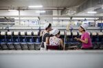 Workers manufacture cotton yarn at a factory in China.