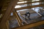 A worker saws a section of lumber inside a home under construction at the M/I Homes Inc. Bougainvillea Place housing development in Ellenton, Florida, U.S., on Thursday, July 6, 2017.