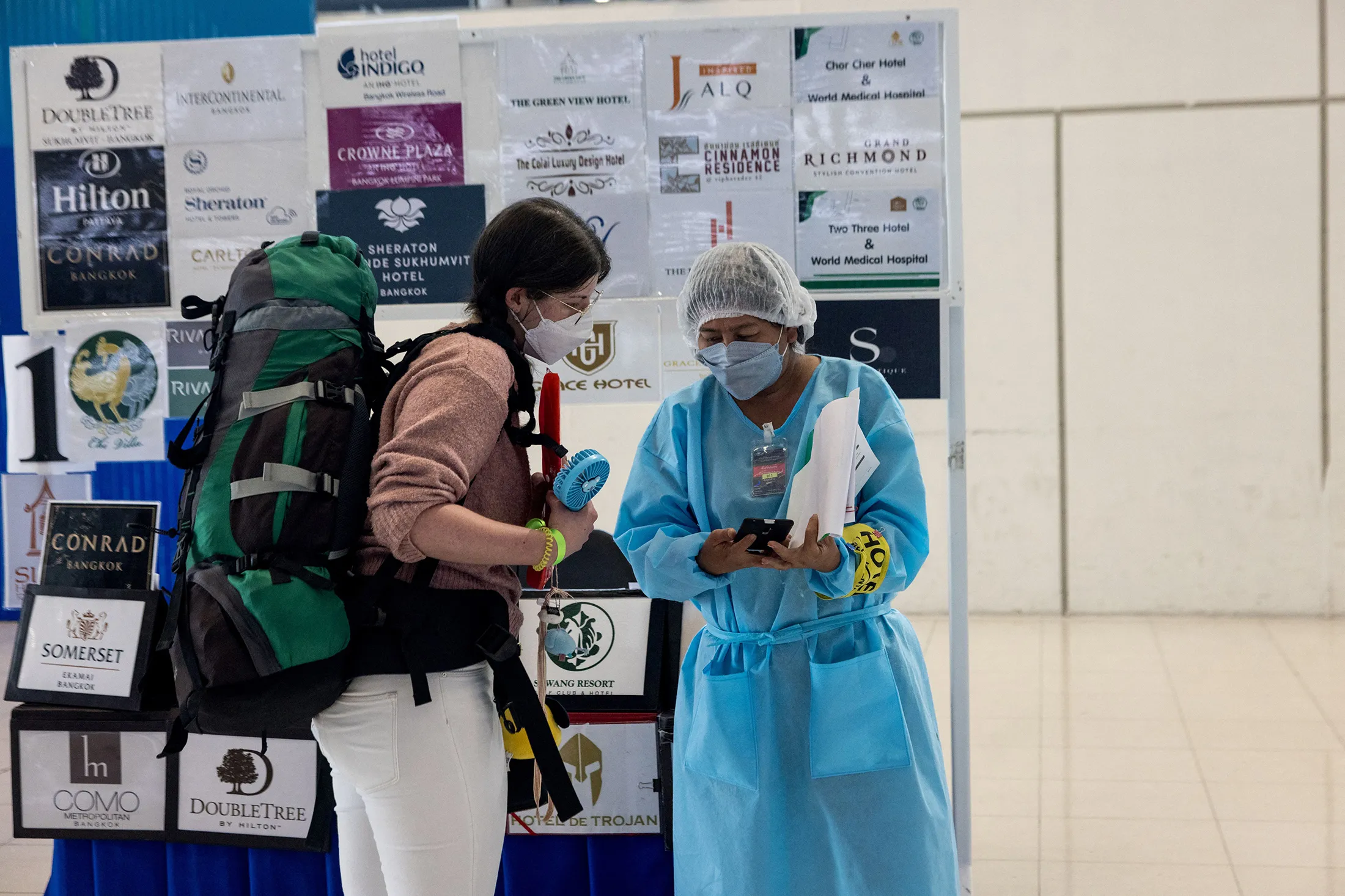 A passenger has her information checked by a hotel representative on arrival at Suvarnabhumi Airport in Bangkok.