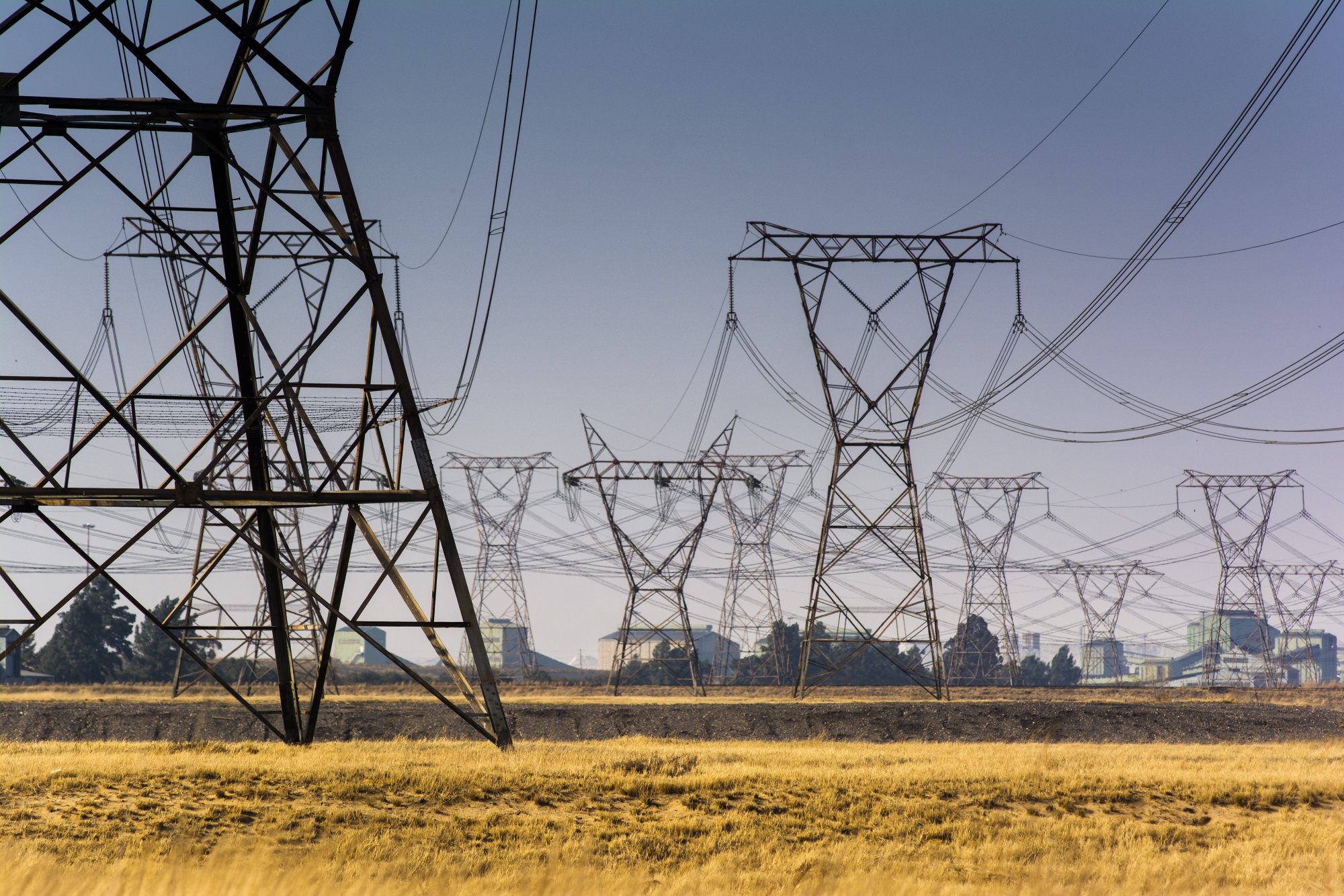 Electrical power lines hang from transmission pylons near an&nbsp;Eskom power station in Vereeniging, South Africa.