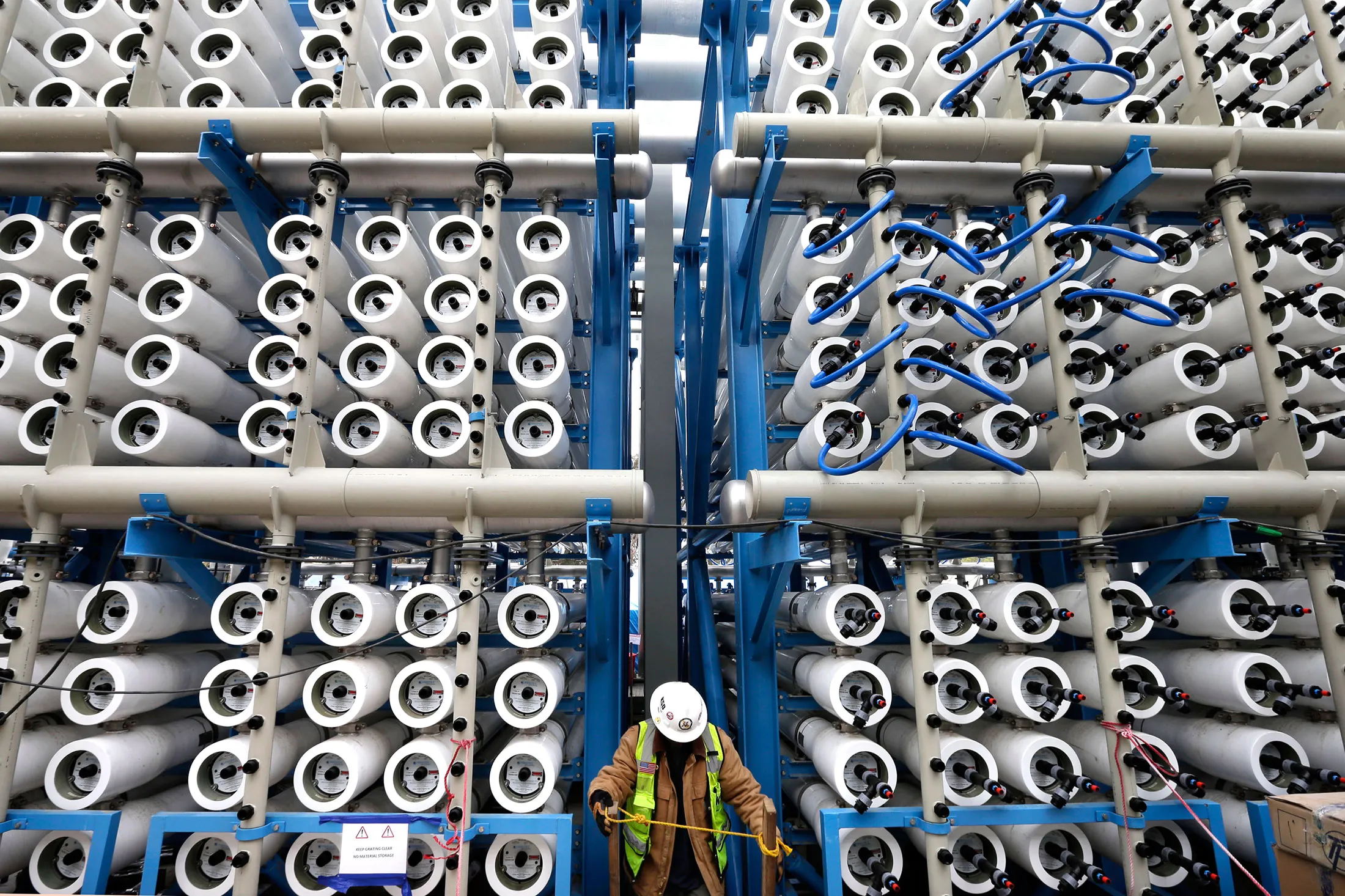 A worker among some of the 2,000 pressure vessels used to convert seawater into fresh water through reverse osmosis in the western hemisphere's largest desalination plant in Carlsbad, California, on March 11, 2015.
