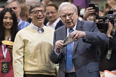 Warren Buffett, Berkshire Hathaway Inc. chairman and chief executive officer, right, talks with Bill Gates, billionaire and co-chair of the Bill and Melinda Gates Foundation, as they tour the exhibition floor during the Berkshire Hathaway Inc. annual shareholders meeting in Omaha, Nebraska, U.S., on Saturday, May 2, 2015. More than 40,000 people are expected Saturday at the Berkshire Hathaway annual meeting, which marks Warren Buffett's 50th year running the company. Photographer: Daniel Acker/Bloomberg *** Local Caption *** Warren Buffett; Bill Gates