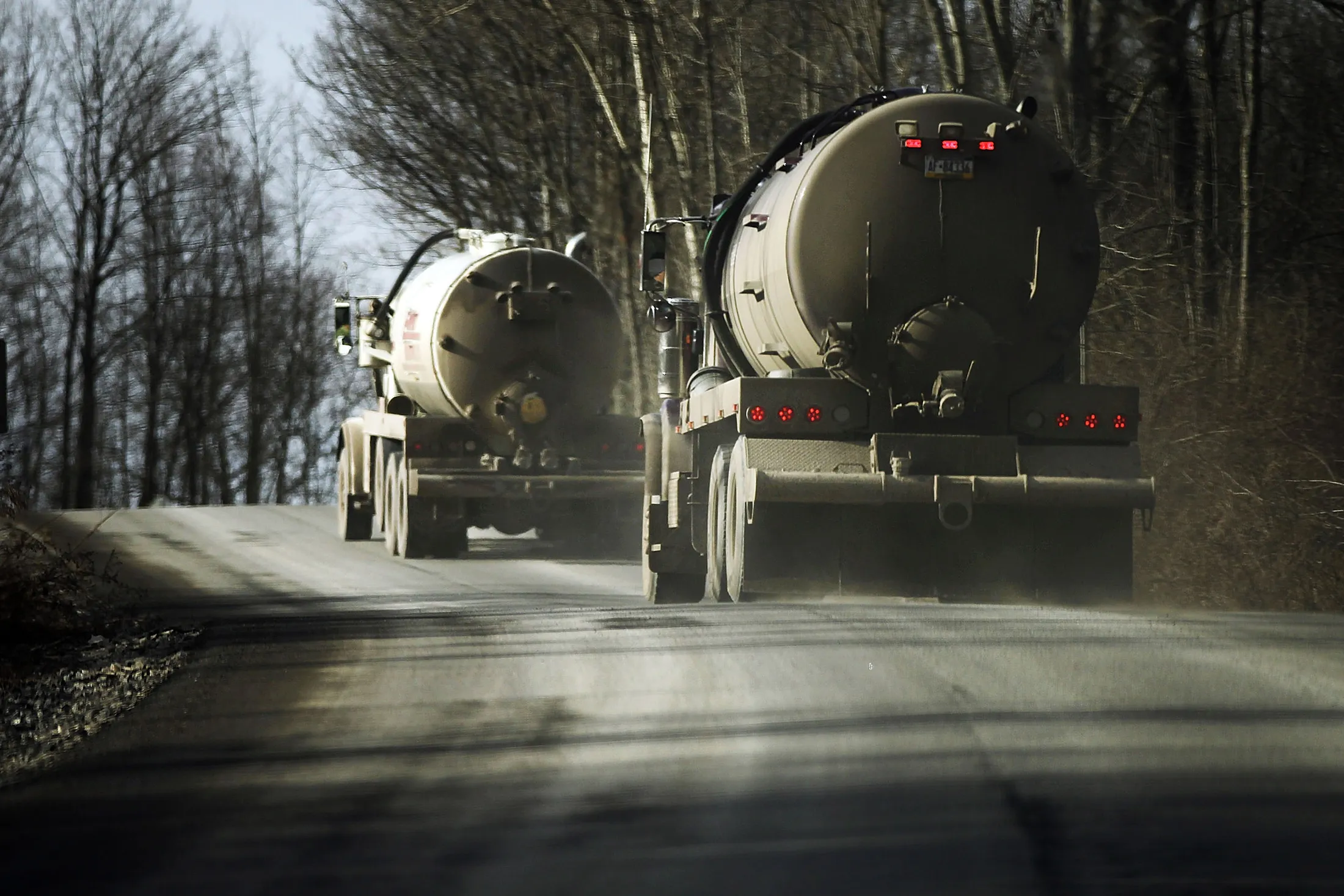 Trucks with the natural gas industry, some of the thousands that pass through the area daily, drive through the countryside in Springville, Pennsylvania.
