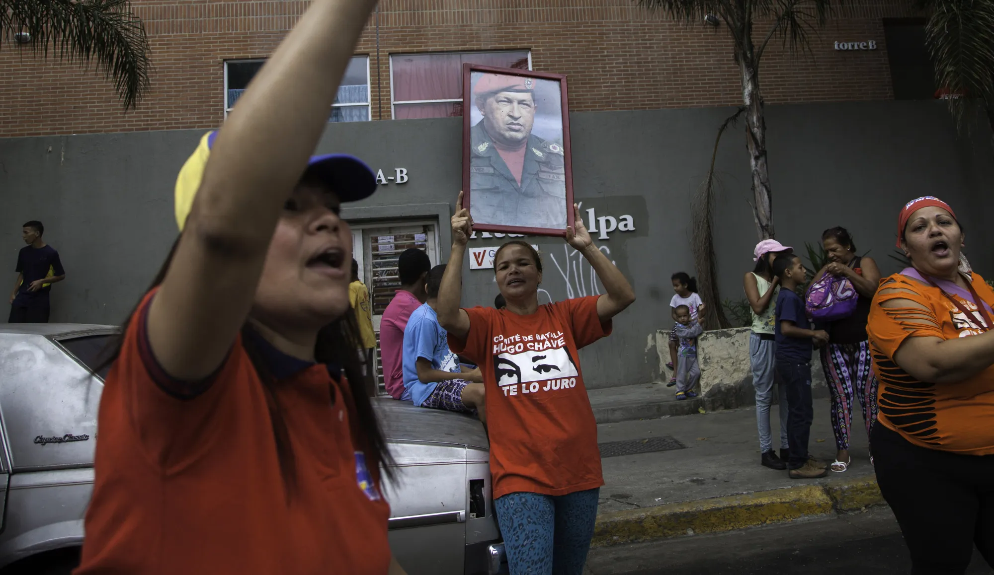 Supporters of Nicolas Maduro, Venezuela's president, not pictured, hold up flags and a picture of Hugo Chavez, former president of Venezuela, during a protest in Caracas, on Sept. 1, 2016.
