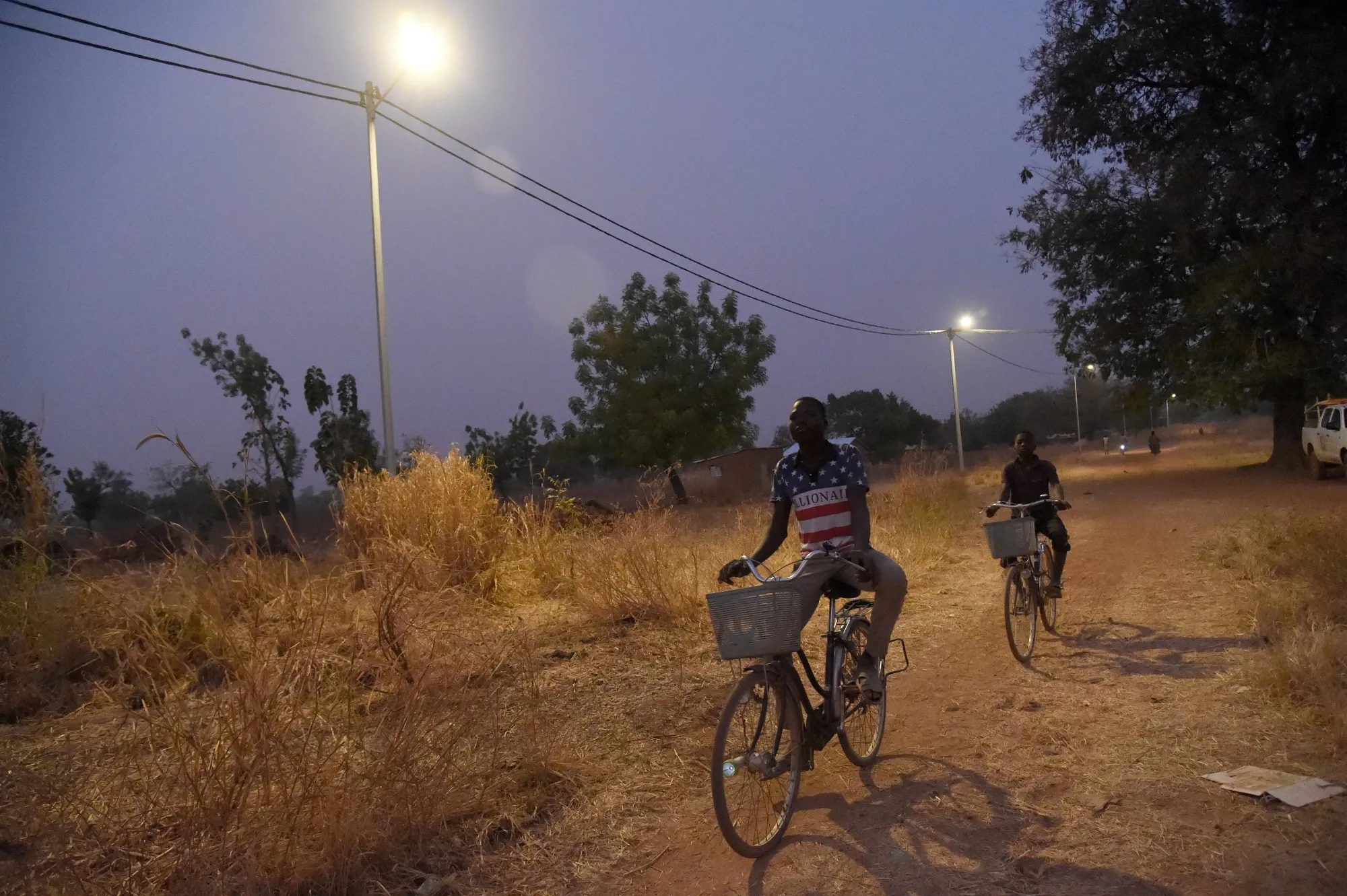 Cyclists ride underneath solar lights in the Takpapieni village in Oti province of northern Togo.&nbsp;