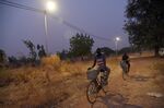 Cyclists ride underneath solar lights in the Takpapieni village in Oti province of northern Togo.