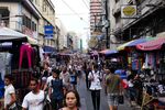 Shoppers and pedestrians walk past market stalls in the Binondo district of Manila, the Philippines
