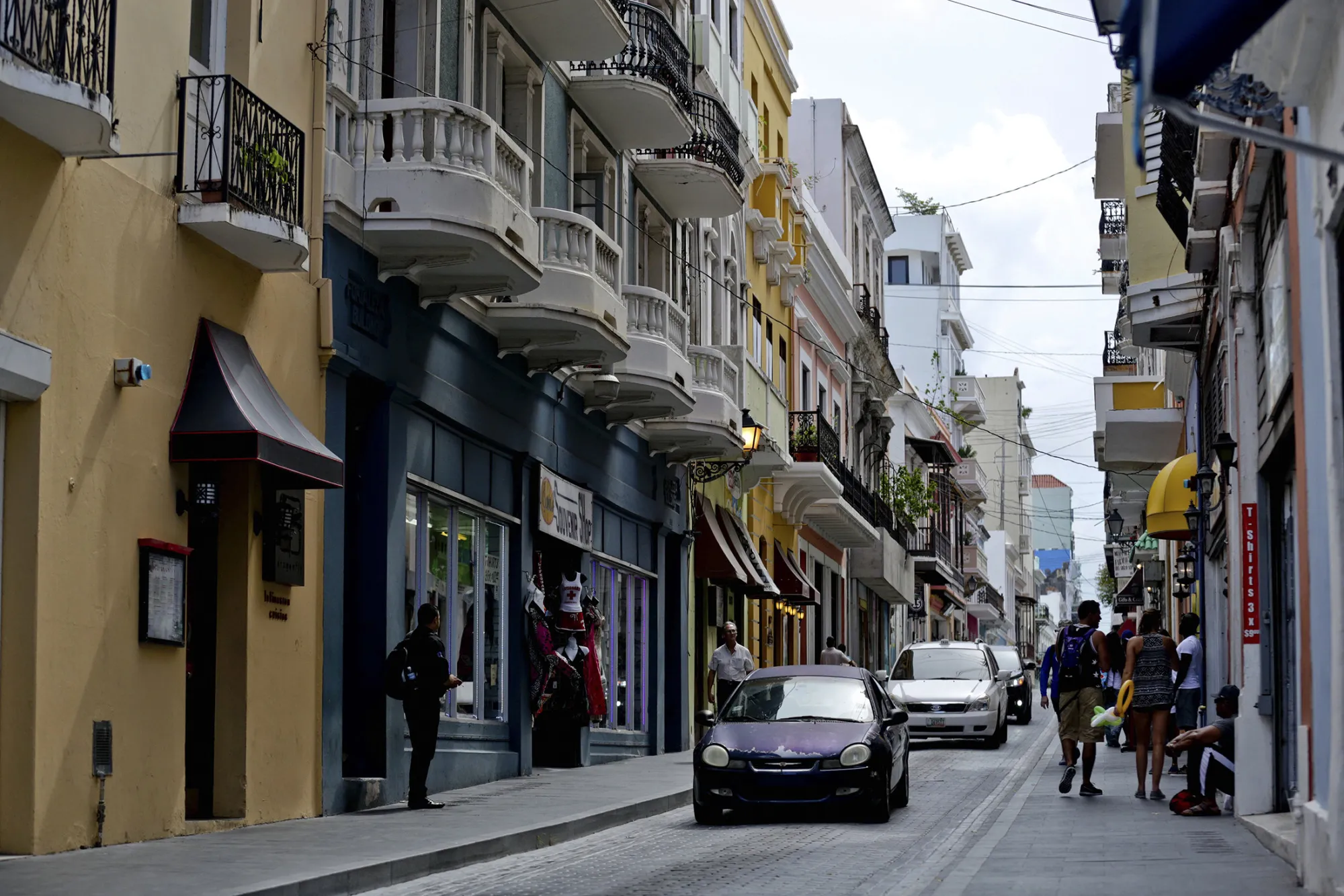 Pedestrians walk along Calle Fortaleza in Old San Juan, Puerto Rico.
