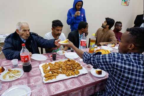 Local residents join refugees for a meal at the Palazzo Condo.