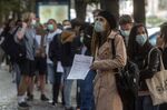 People wearing protective face masks wait in line at a coronavirus testing center in Prague on Sept. 21.