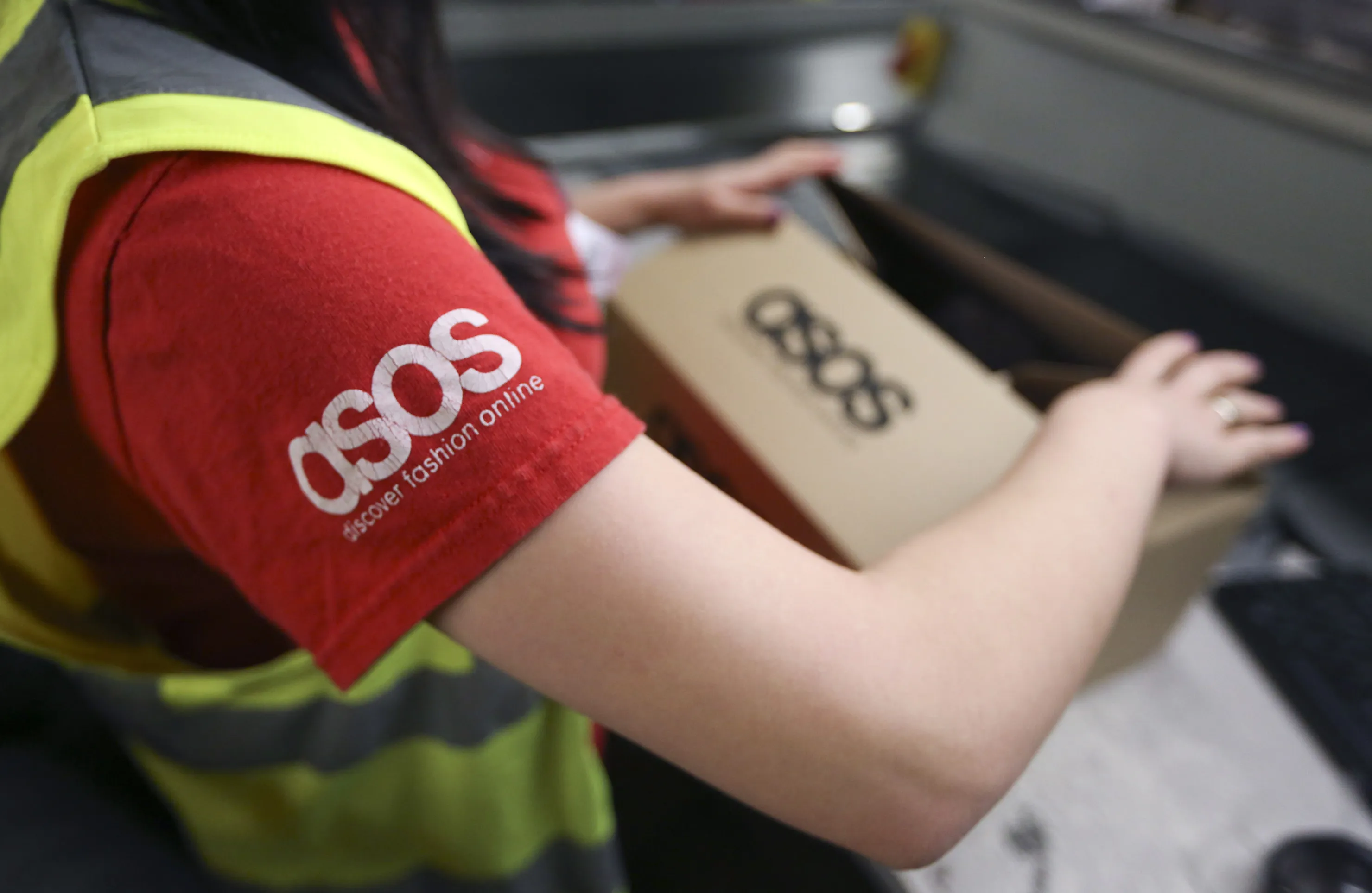 A worker completes a customer's order&nbsp;at Asos Plc's distribution warehouse in Barnsley, U.K.