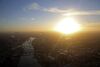 The early morning sun rises on the horizon beyond the Shard, in this aerial photograph looking south east along the River Thames towards Canary Wharf from the City of London, U.K.