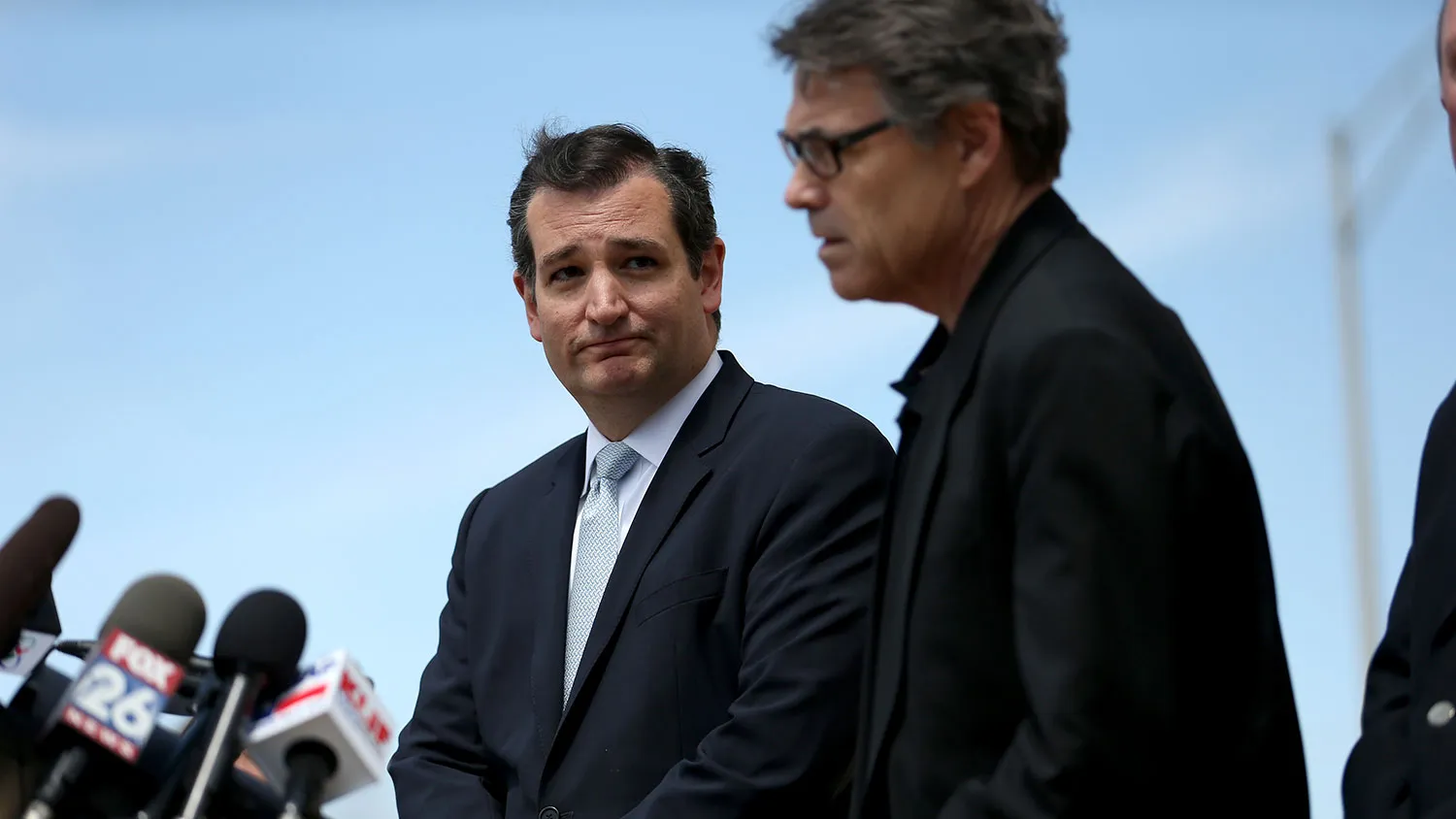 Senator Ted Cruz and then-Governor Rick Perry speak during a press conference at the front gate of Fort Hood on April 4, 2014, in Fort Hood, Texas.
