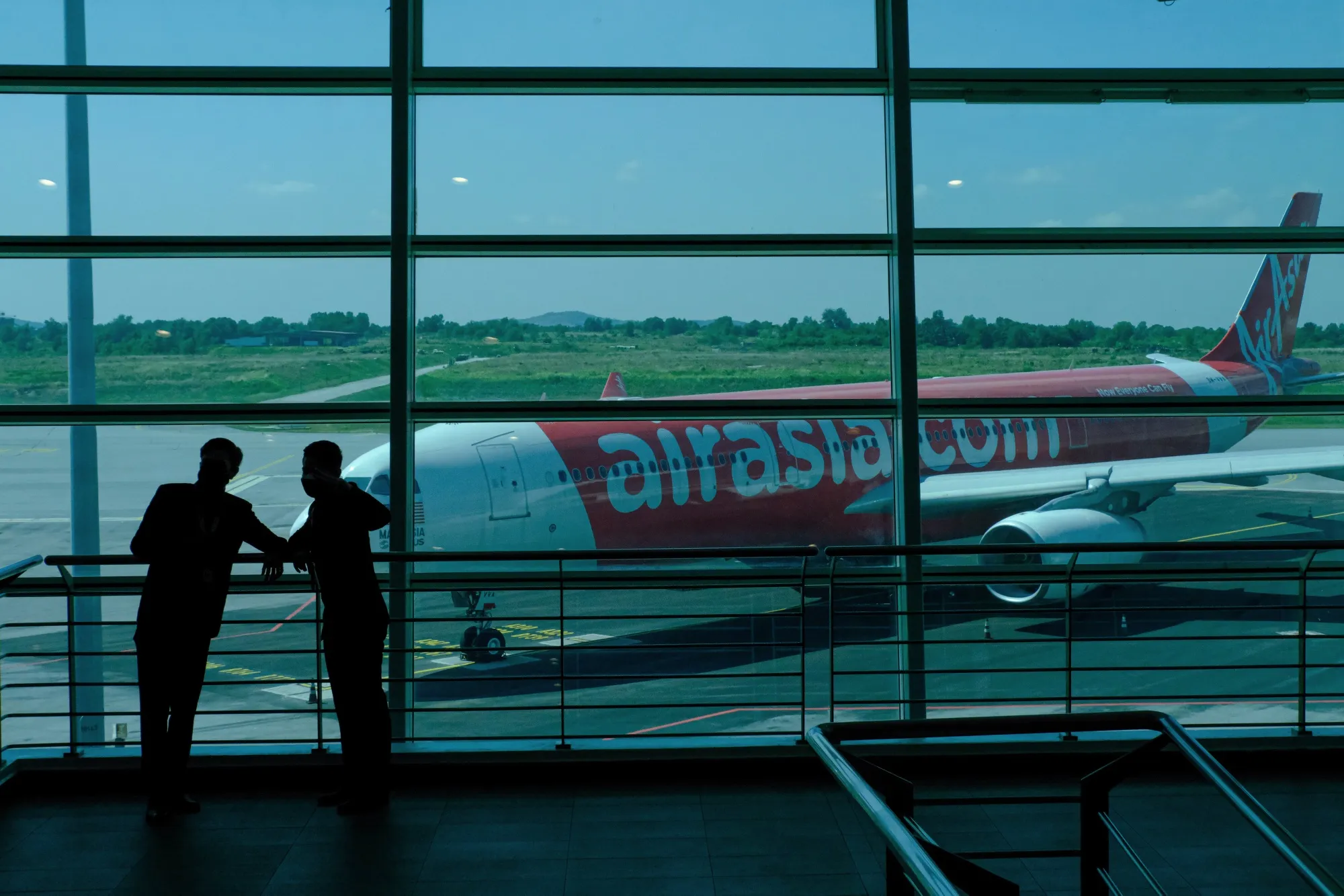 AirAsia staff silhouetted in front of an aircraft at Kuala Lumpur International Airport.