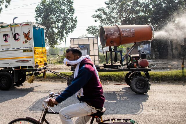 An anti-smog gun sprays water on a busy road to settle the particles in the air, in Muzaffarnagar District, Uttar Pradesh, India, on Friday, Nov. 18, 2022.