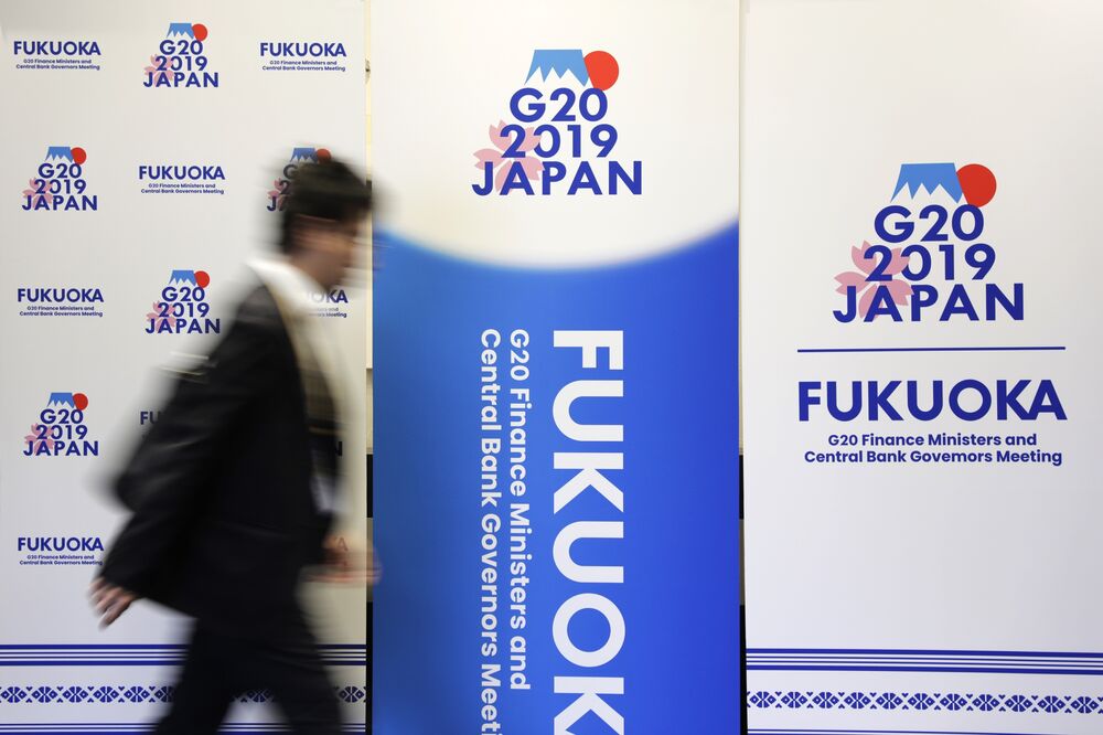 A man walks past banners for the Group of 20 (G-20) finance ministers and central bank governors meeting outside the media center of the meeting in Fukuoka, Japan. 