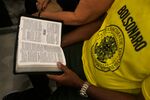 A man wearing a T-shirt with the inscription &quot;Bolsonaro&quot; reads the Bible during an evangelical service in 2018, before Jair Bolsonaro was elected president in Brazil.