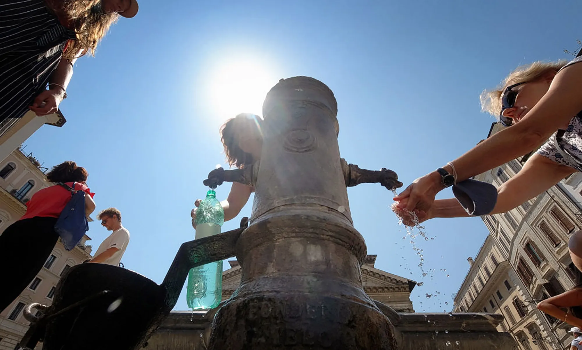 A tourist refreshes himself and fills bottle of water in a "Nasone" fountain in the center of Rome on August 12, 2020. - Western Europe has been sweltering through a heatwave, with temperatures soaring above 35 degrees Celsius (95 F). (Photo by Alberto PIZZOLI / AFP) (Photo by ALBERTO PIZZOLI/AFP via Getty Images)