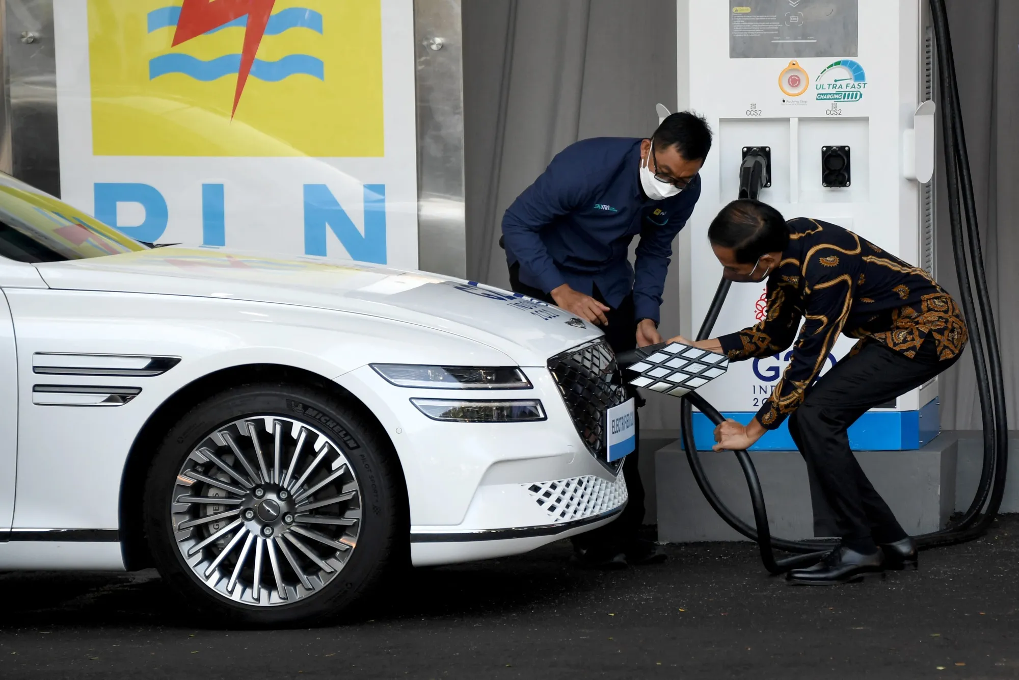 Indonesia's President Joko Widodo helps charge an electric car at the launch of the first public electric vehicle charging station, in Bali in March.