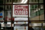 A sign reads "Sorry We're Closed" in a restaurant window in Detroit on March 31.