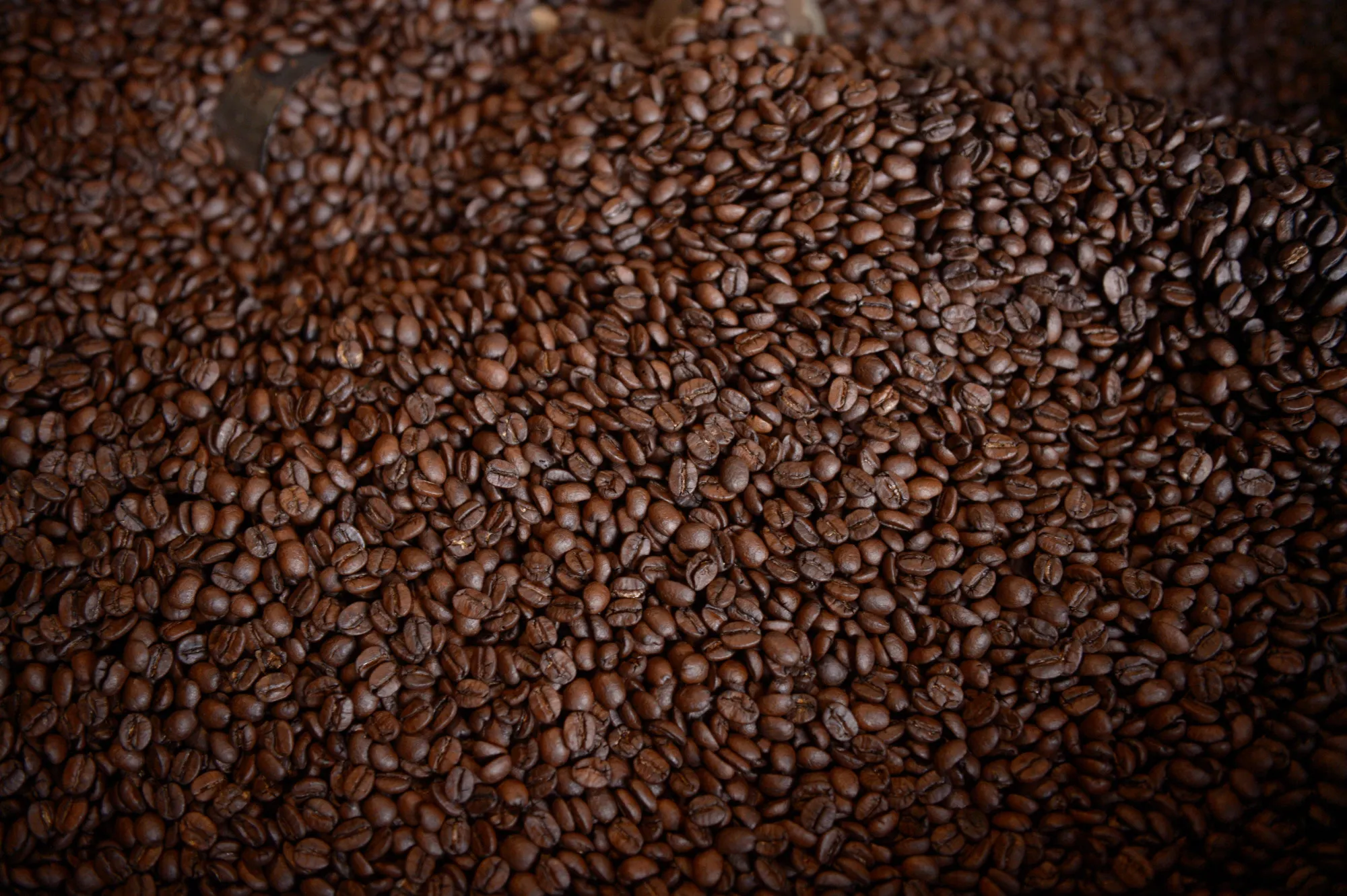 Freshly roasted coffee beans sit in a roasting tub at the Skybury Coffee Pty coffee plantation in the Atherton Tablelands, Queensland, Australia, on Tuesday, Aug. 1, 2017. While Australia’s second-quarter economic growth data will be a highlight next week, currency traders are more likely to look toward a widening yield spread with the U.S., rising commodity prices and improving jobs data for catalysts to lift the Aussie above 80 cents.
