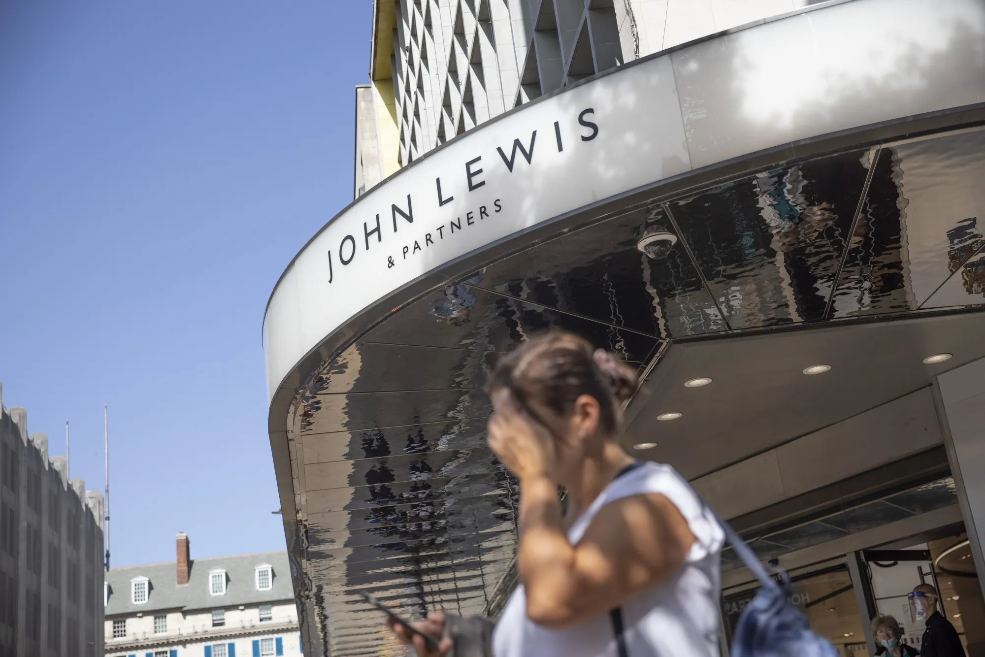Pedestrians pass a John Lewis Partnership Plc&nbsp;department store on Oxford Street in London.