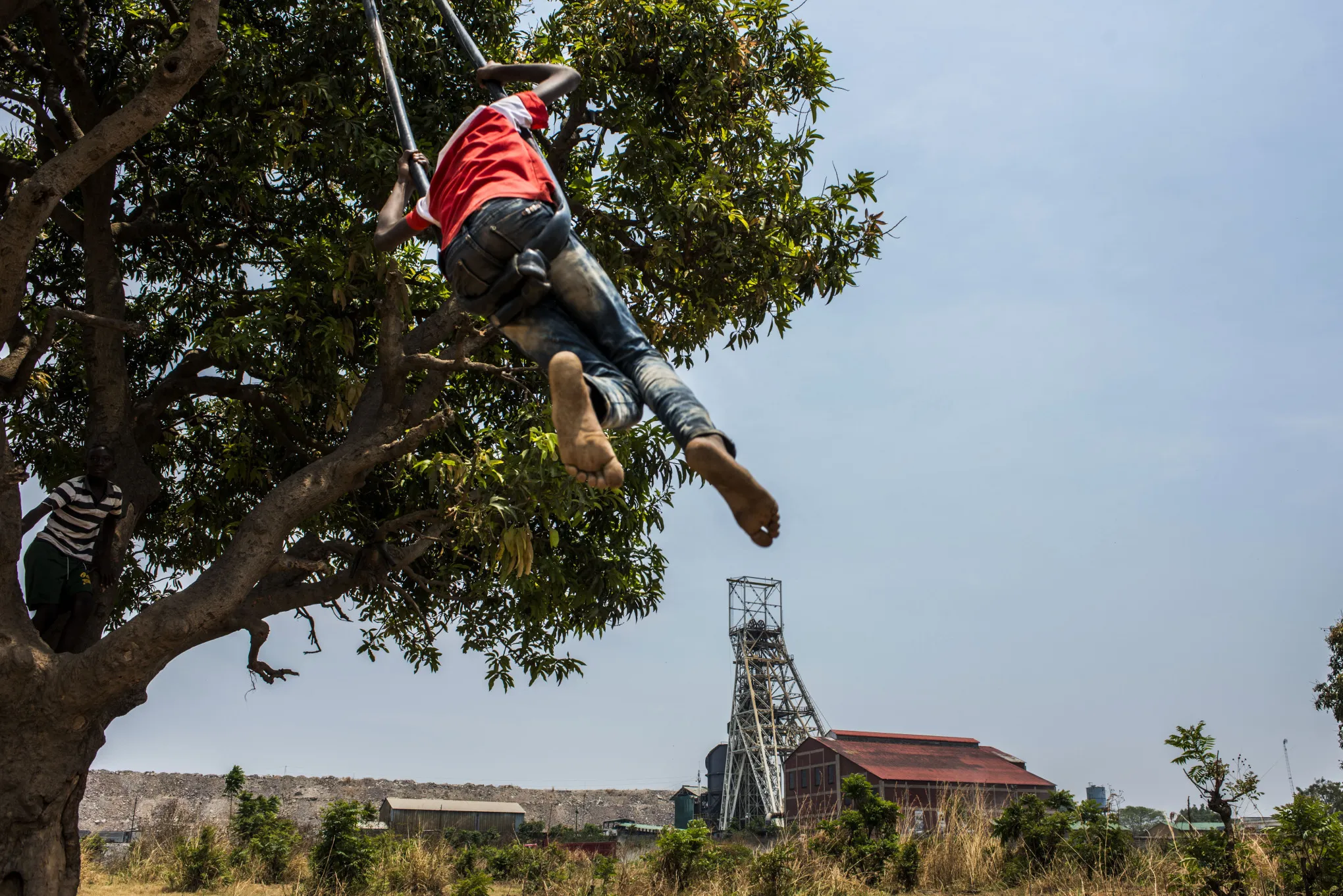Children play on a tree swing on waste ground near the Glencore's Mopani Copper mine.
