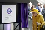 Queen Elizabeth II unveils a plaque to mark the Elizabeth line's official opening at Paddington station in London on May 17.
