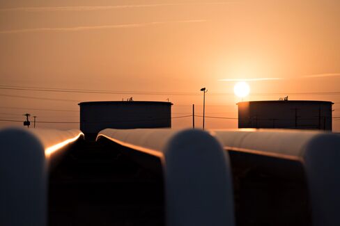 The sun rises beyond oil storage tanks at the Enbridge Cushing storage terminal in Cushing, Okla., on March 25.