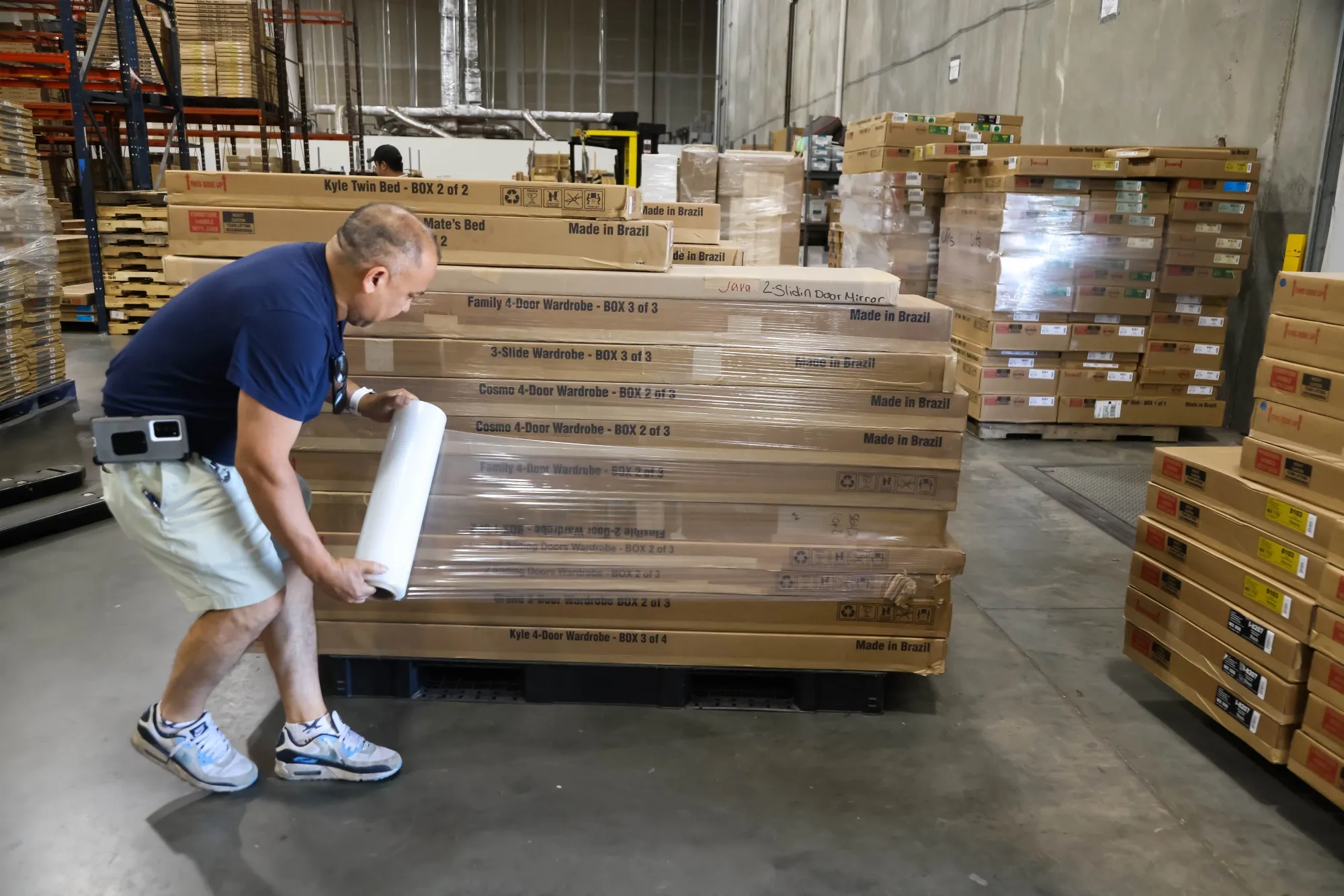 A worker wraps plastic around a pallet of furniture at the Palace Imports warehouse in Linden, New Jersey, US.