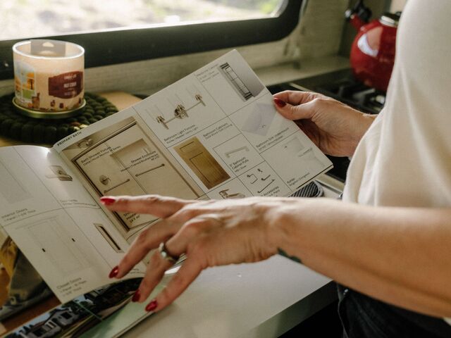 Rebecca showing a catalog for house fixtures.