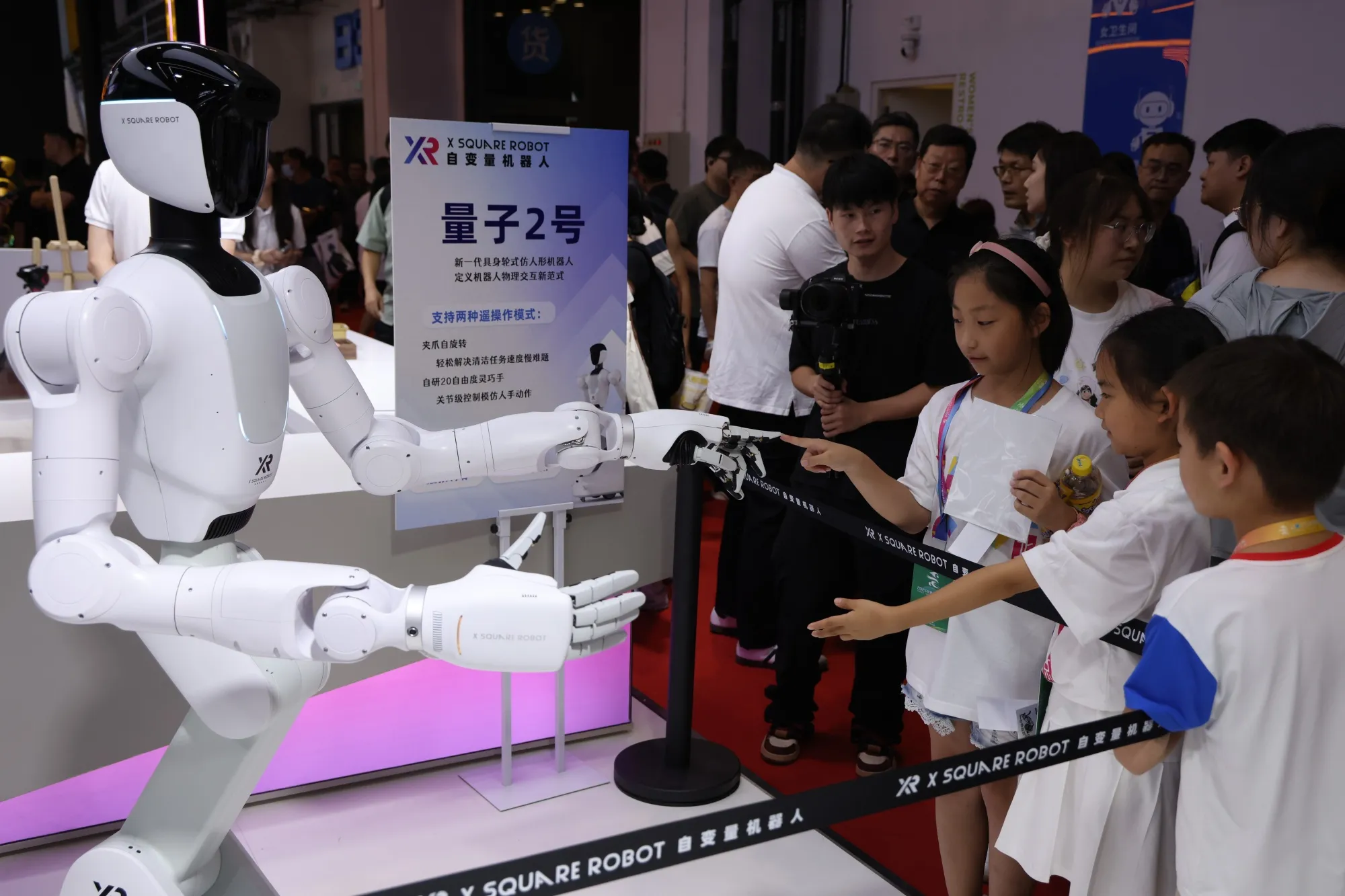 Visitors interact with a Quanta X2 robot from X Square Robot at the 2025 World Robot Conference WRC in Beijing.