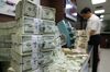 An employee counts bundled U.S. 100 dollar notes at the Korea Exchange Bank headquarters in Seoul, South Korea, on Monday, Aug. 8, 2011.
