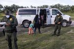 Migrants are apprehended by U.S. Customs and Border Protection agents after crossing the Rio Grande in LaJoya, Texas.