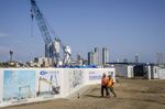 Workers pass hoardings for the Colombo Port City, developed by China Harbour Engineering Co., a unit of China Communications Construction Co., in Colombo, Sri Lanka, in 2018.