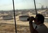 An employee uses binoculars to look out towards the Arabian Sea in the Port Control Center at Saudi Aramco's Ras Tanura oil refinery and terminal in Ras Tanura, Saudi Arabia, on Monday, Oct. 1, 2018.