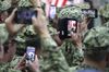 U.S. military personnel use smartphones to take photographs of U.S. President Donald Trump and U.S. First Lady Melania Trump at the U.S. naval base in Yokosuka, Kanagawa Prefecture.