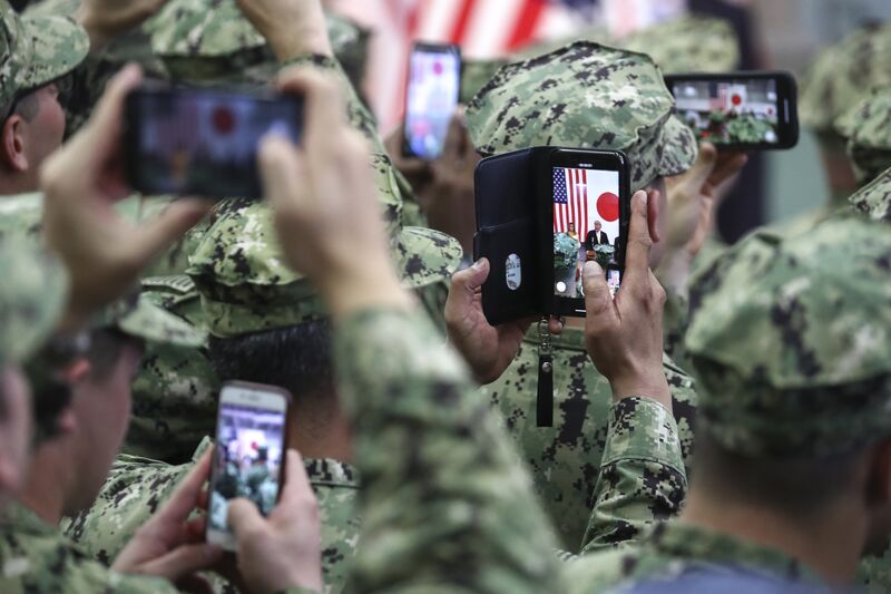 U.S. military personnel use smartphones to take photographs of U.S. President Donald Trump and U.S. First Lady Melania Trump at the U.S. naval base in Yokosuka, Kanagawa Prefecture.