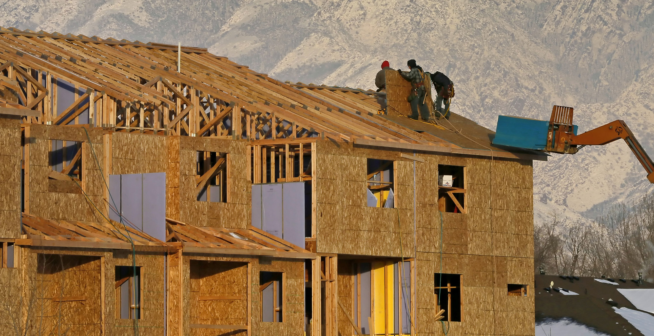 Contractors work on the roof of a new residential apartment building in Sandy, Utah.
