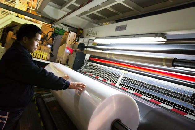 Ngo Tien Thanh from Vietnam works on the production line manufacturing shrink-wrap at the Homyeong Chemical Industrial factory in Pocheon, South Korea