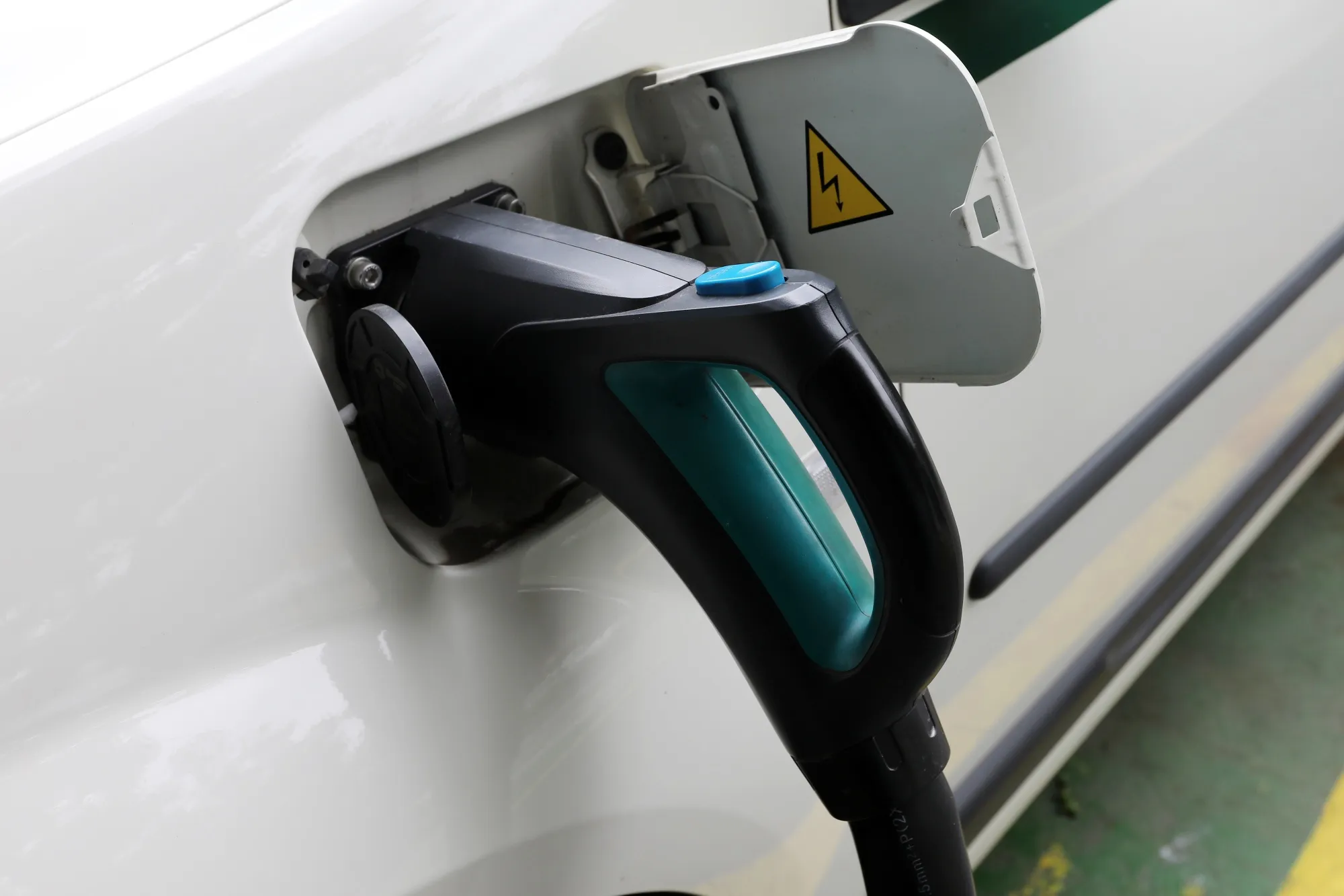 A charging plug is connected to an electric vehicle (EV) in New Delhi. Photographer T. Narayan/Bloomberg