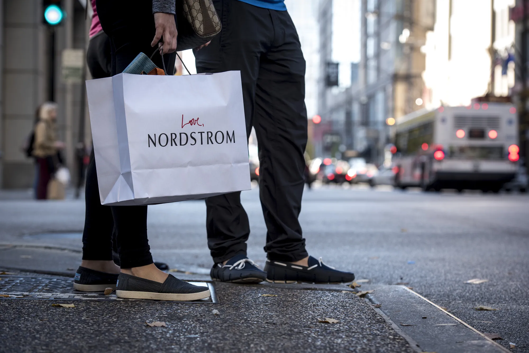 A pedestrian carries a Nordstrom Inc. shopping bag in Chicago, Illinois.