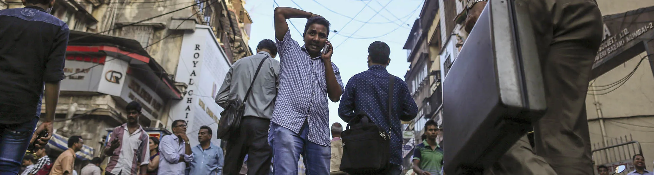 Pedestrians walk past jewelry and bullion stores in the Zaveri Bazaar in Mumbai, India, on Monday, May 2, 2016. Prime Minister Narendra Modi in March imposed a 1 percent excise duty on jewelry, prompting protests from thousands of manufacturers and artisans across India. Kumar Jain, owner of Umedmal Tilokchand (U.T) Zaveri jewelry store, says the extra burden is dealing a financial blow and will cost Modi the support of most of the country's roughly 3.5 million jewelers, designers and artisans.
