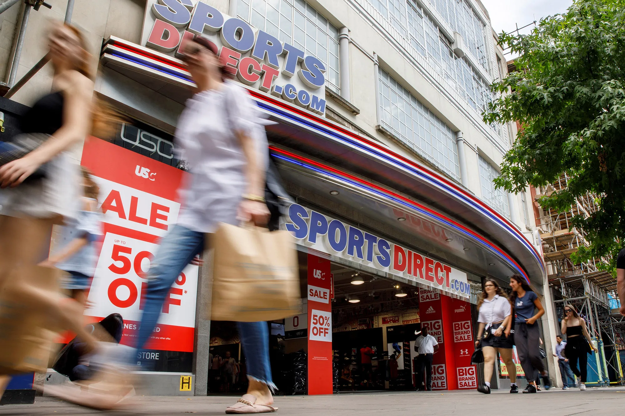 Shoppers walk past a Sports Direct store in London.&nbsp;