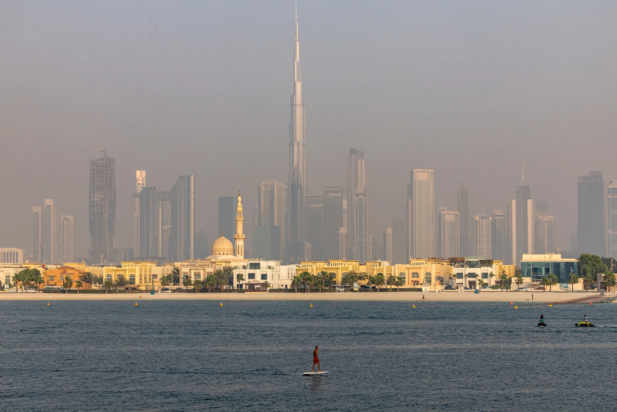 A fly boarder passes the Burj Khalifa skyscraper, center, on the city skyline in the Jumeirah Beach district of Dubai.