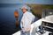 Daryl Carpenter aboard one of his fishing charter boats in the saltwater wetlands near Grand Isle, La., with a barrier erected by a private landowner.