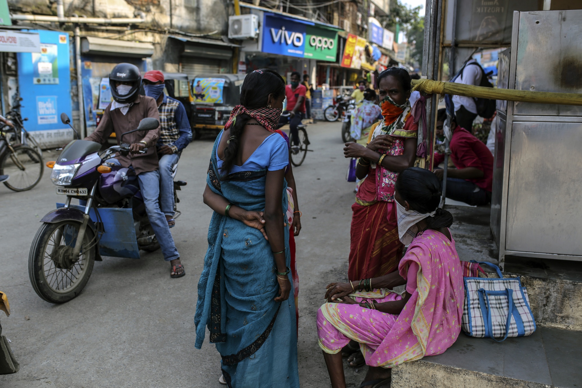 Daily wage workers waiting for work along a street in Boisar, Maharashtra, India.