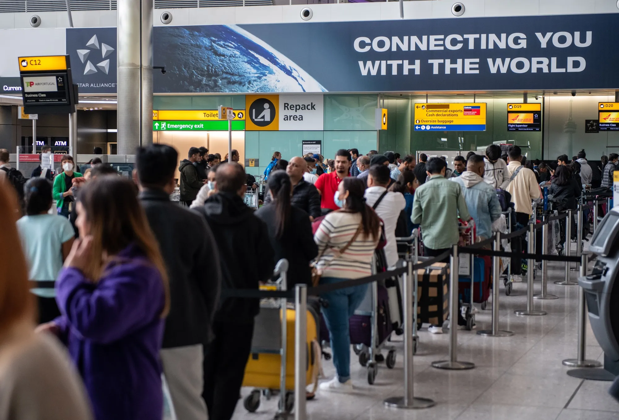 Passengers queue to check in at London Heathrow Airport in April.&nbsp;