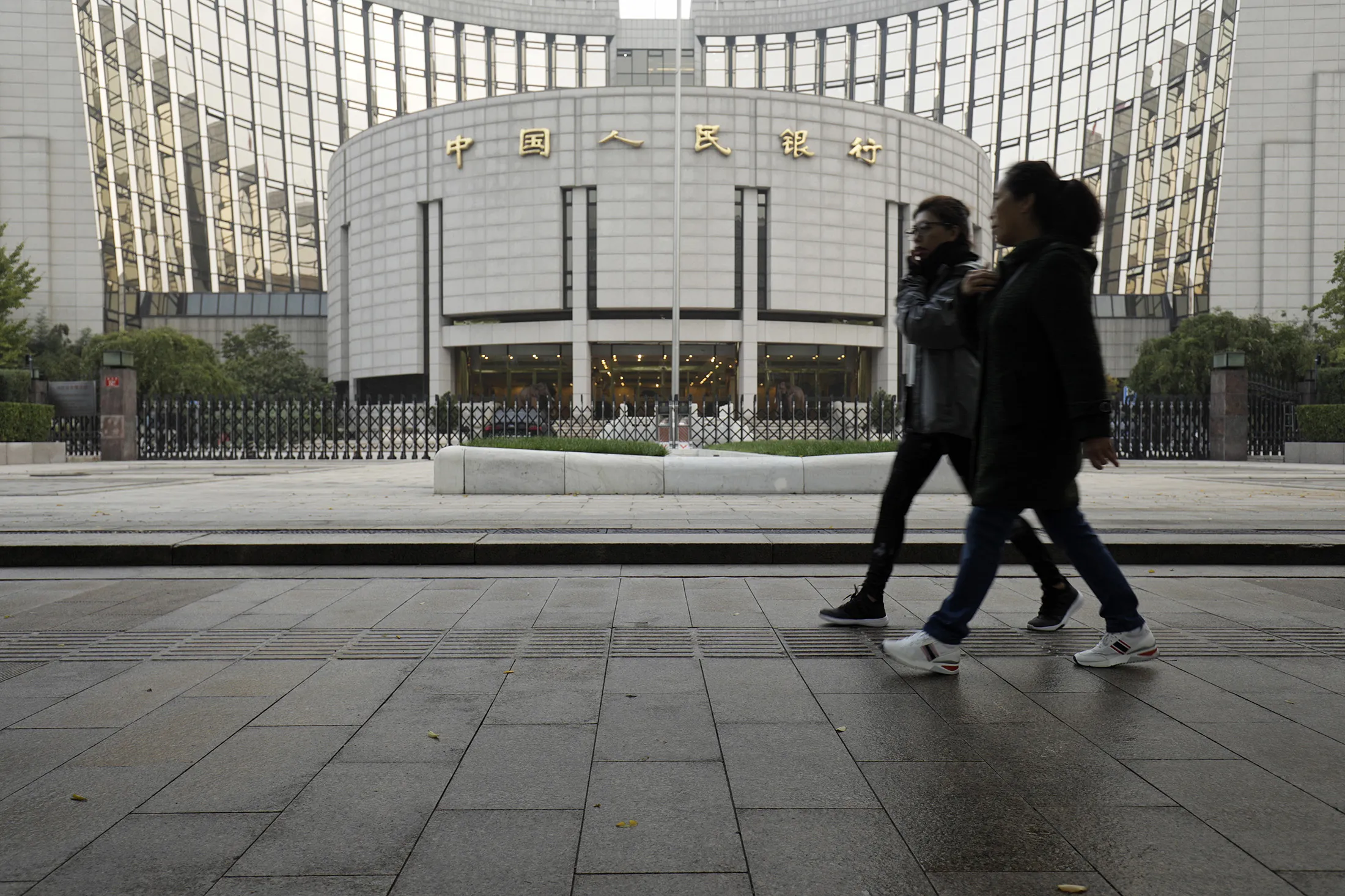 Pedestrians walk past the People's Bank of China headquarters in Beijing.